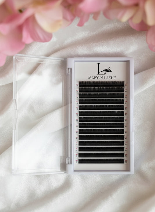 Maison Lashé Cashmere Silk Lash Tray featuring 16 ultra-soft matte black lash lines in various lengths, presented on satin with pink floral decor – ideal for classic, volume, and hybrid eyelash extensions.